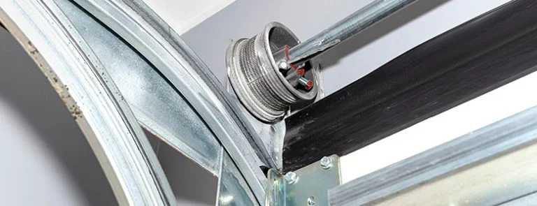 Close-up of a garage door cable drum and track mechanism.