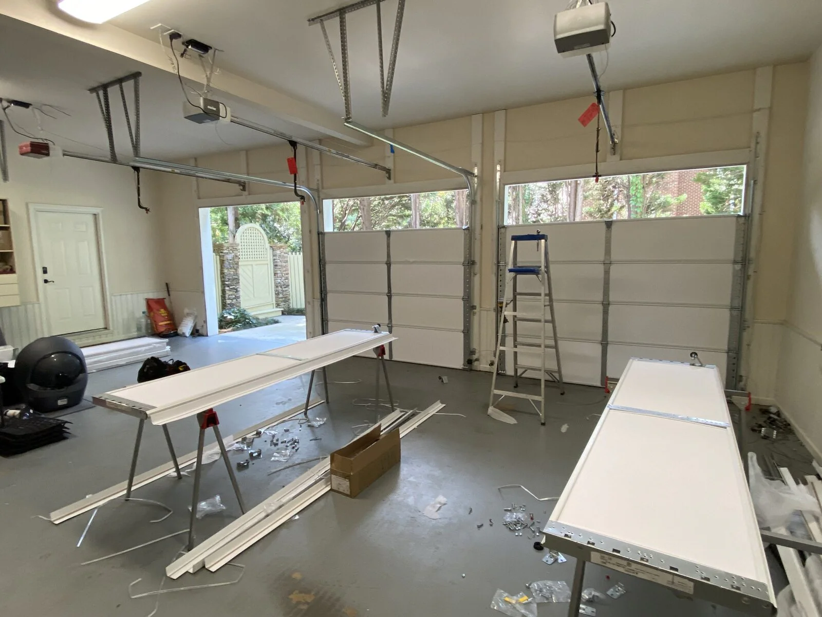 Garage interior with new white garage door panels on sawhorses